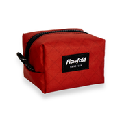 Red toiletry bag with 'Flowfold' logo on a white background