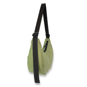 Green crescent bag with a black strap on a white background