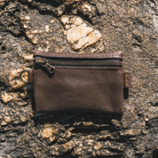 Brown leather pouch on a textured stone surface