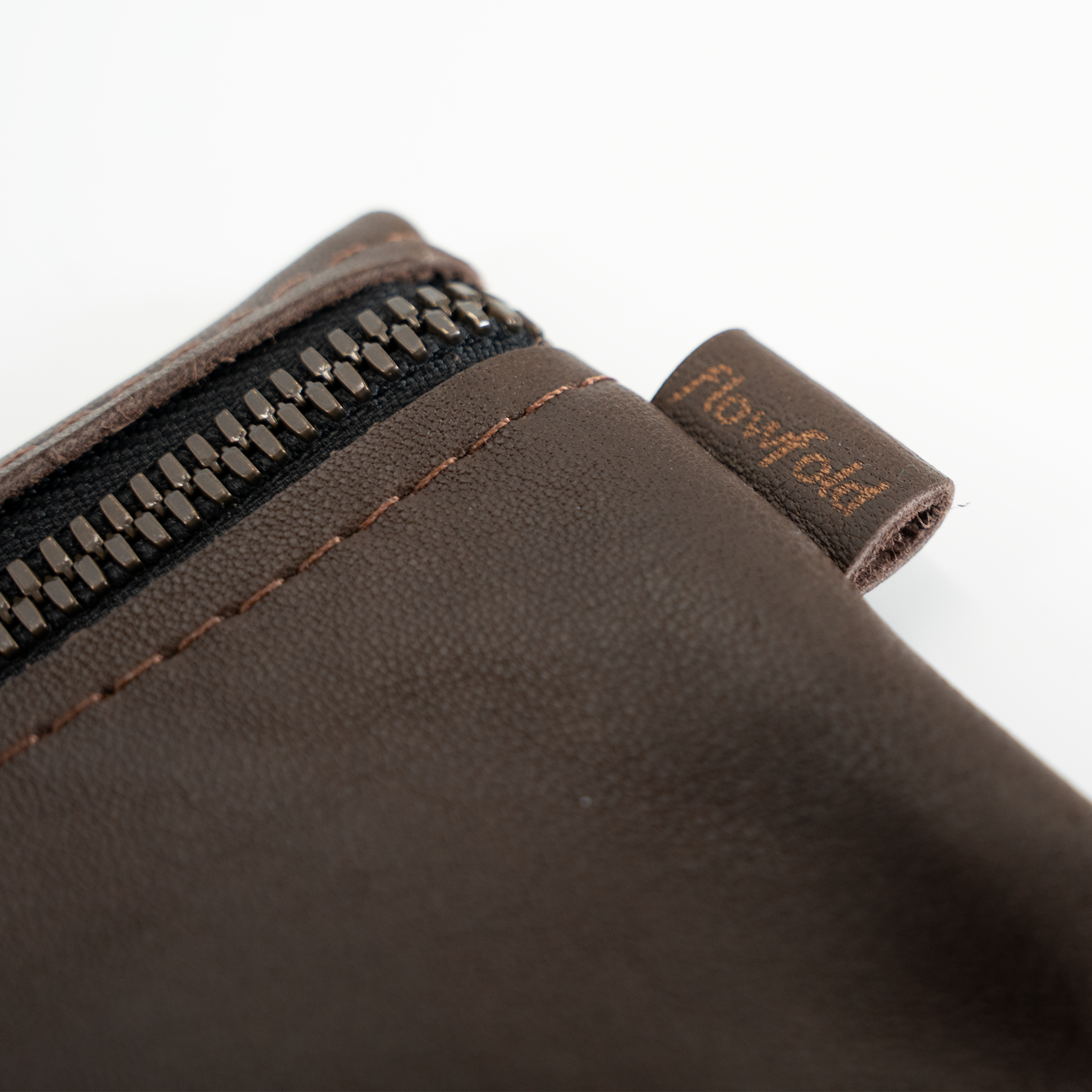Close-up of a brown leather wallet with a zipper and 'Flowfold' brand name on a white background