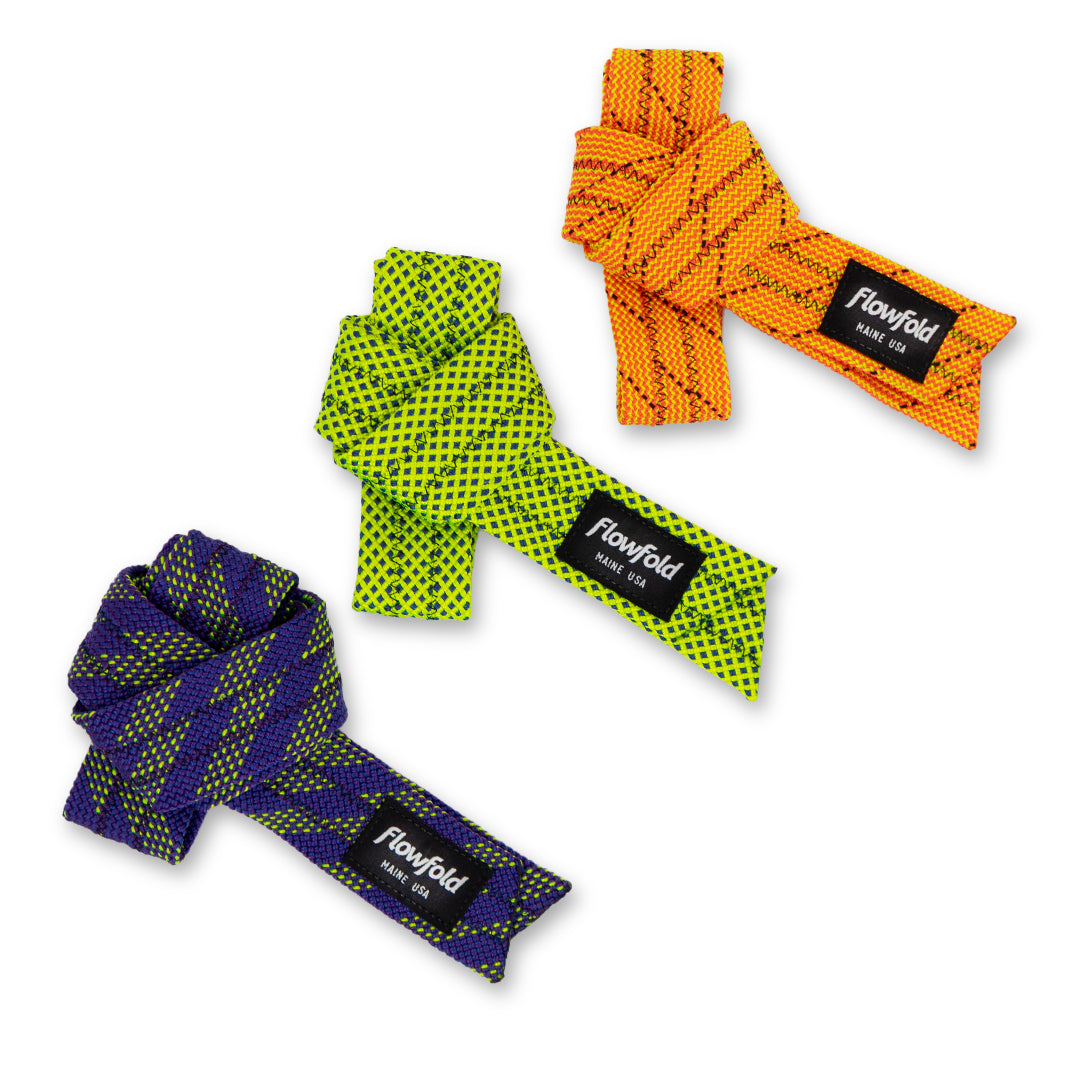 Hollow rope straps in tangerine, lime, and eggplant tied and placed in a row with the flowfold label visible
