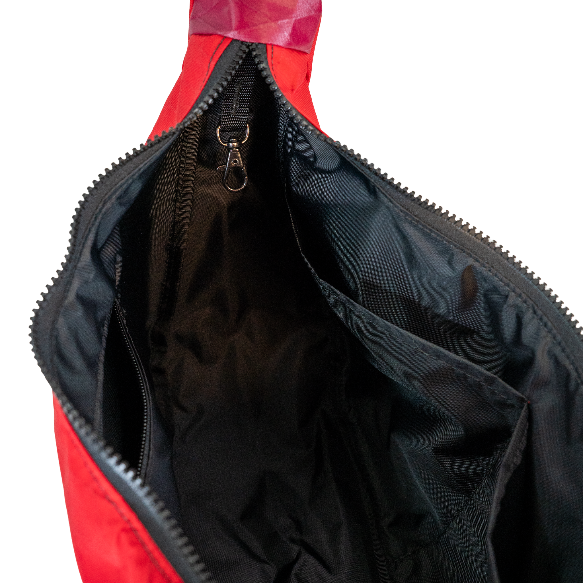 Black interior lining of the crescent shaped crossbody bad with two slip pockets, a zip pocket, and a key leash.