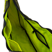 Neon yellow interior lining of the crescent shaped crossbody bad with two slip pockets, a zip pocket, and a key leash. 