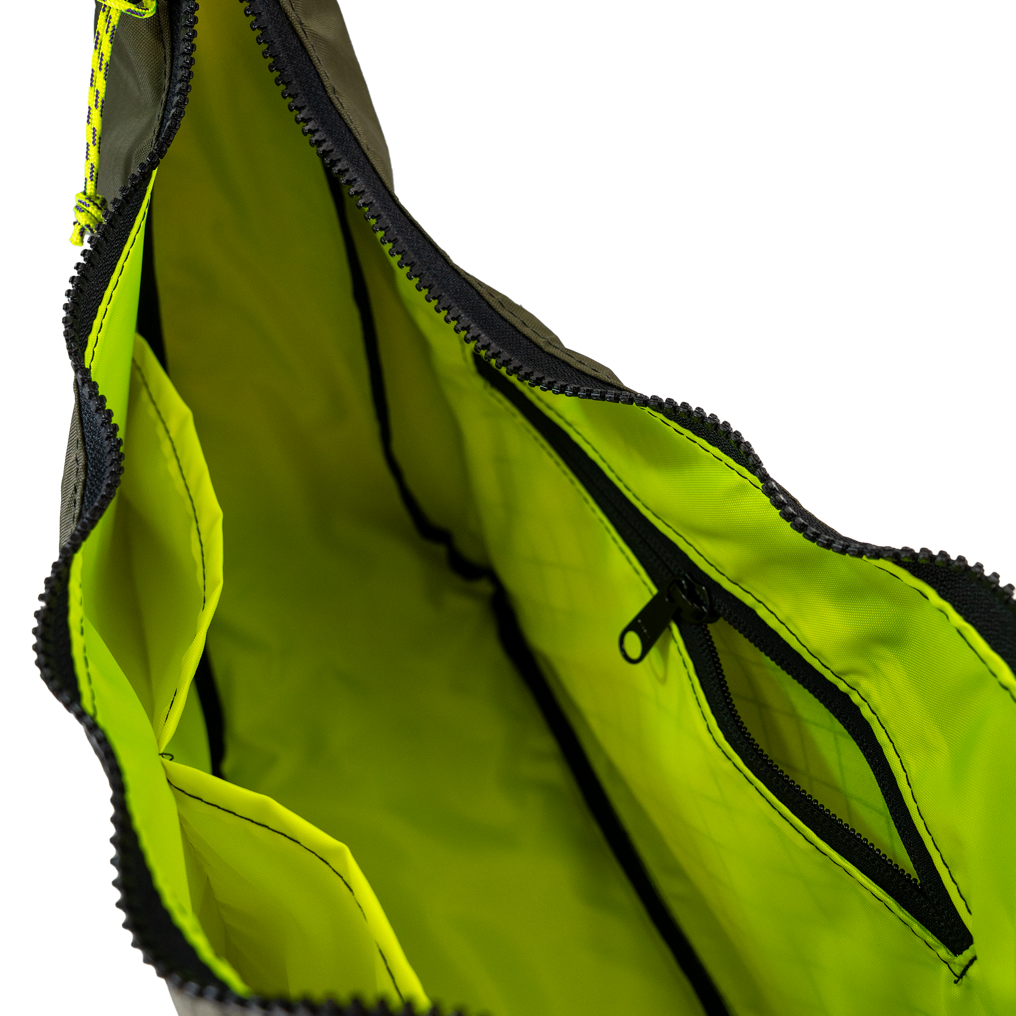 Neon yellow interior lining of the crescent shaped crossbody bad with two slip pockets, a zip pocket, and a key leash. 