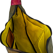 Yellow interior lining of the crescent shaped crossbody bad with two slip pockets, a zip pocket, and a key leash.
