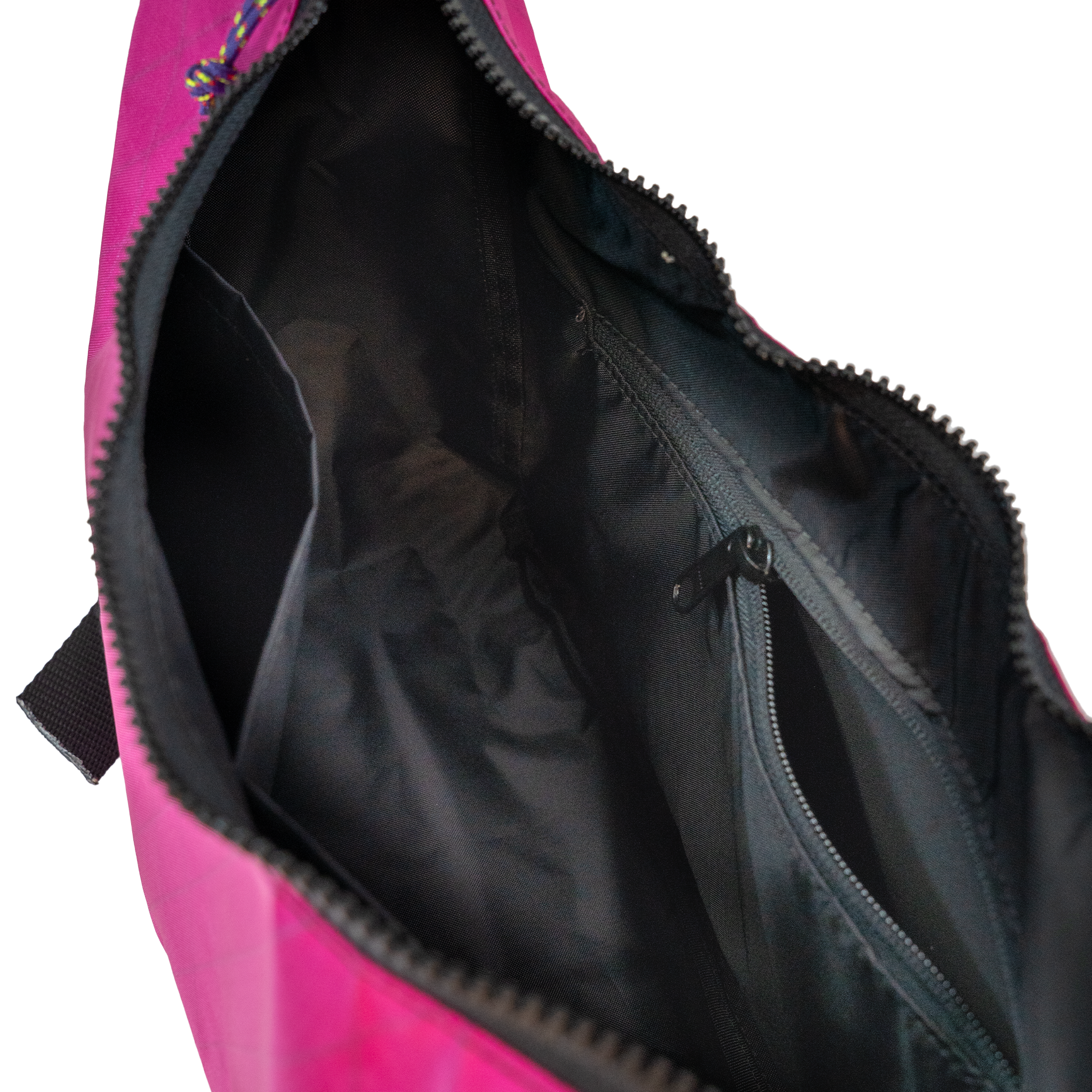 Black interior lining of the crescent shaped crossbody bad with two slip pockets, a zip pocket, and a key leash.