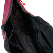 Black interior lining of the crescent shaped crossbody bad with two slip pockets, a zip pocket, and a key leash.