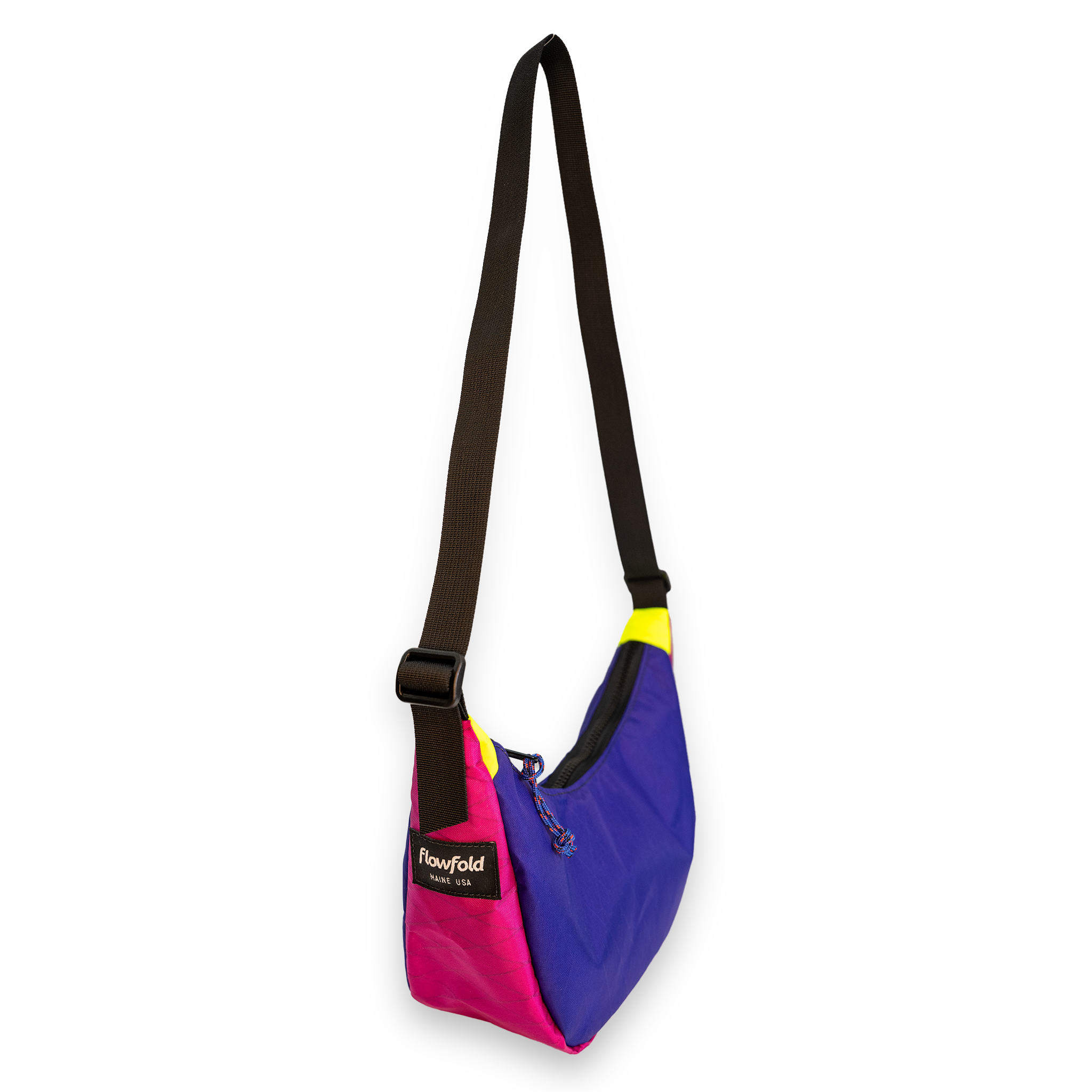 A multicolor shoulder bag by Flowfold, featuring a bright pink and purple body, a black adjustable strap, and a small yellow accent near the top, shown on a plain white background.