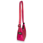 A pink shoulder bag with a matching pink webbing strap and a black brand label that reads 'flowfold'.