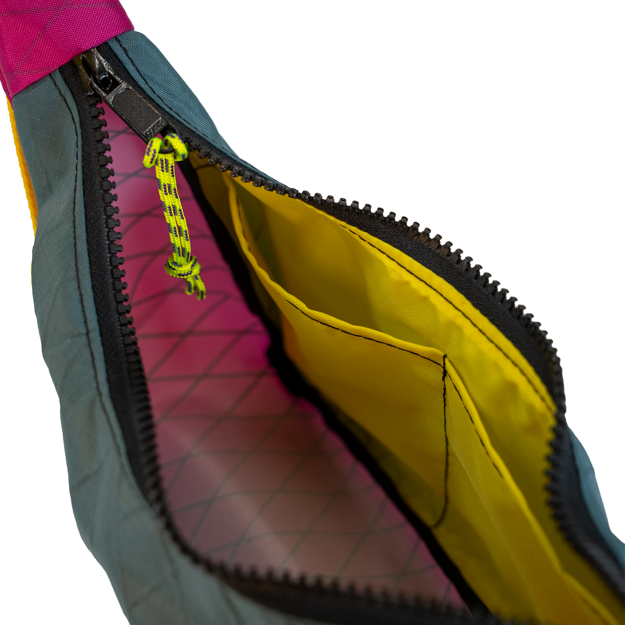 Close-up of a colorful bag with a dark teal exterior, bright yellow interior lining, and a yellow zipper pull accent.