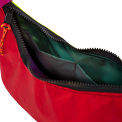 Close-up of a red bag with an open black zipper, showing a dark green interior lining and a small orange-and-black zipper pull on a white background.