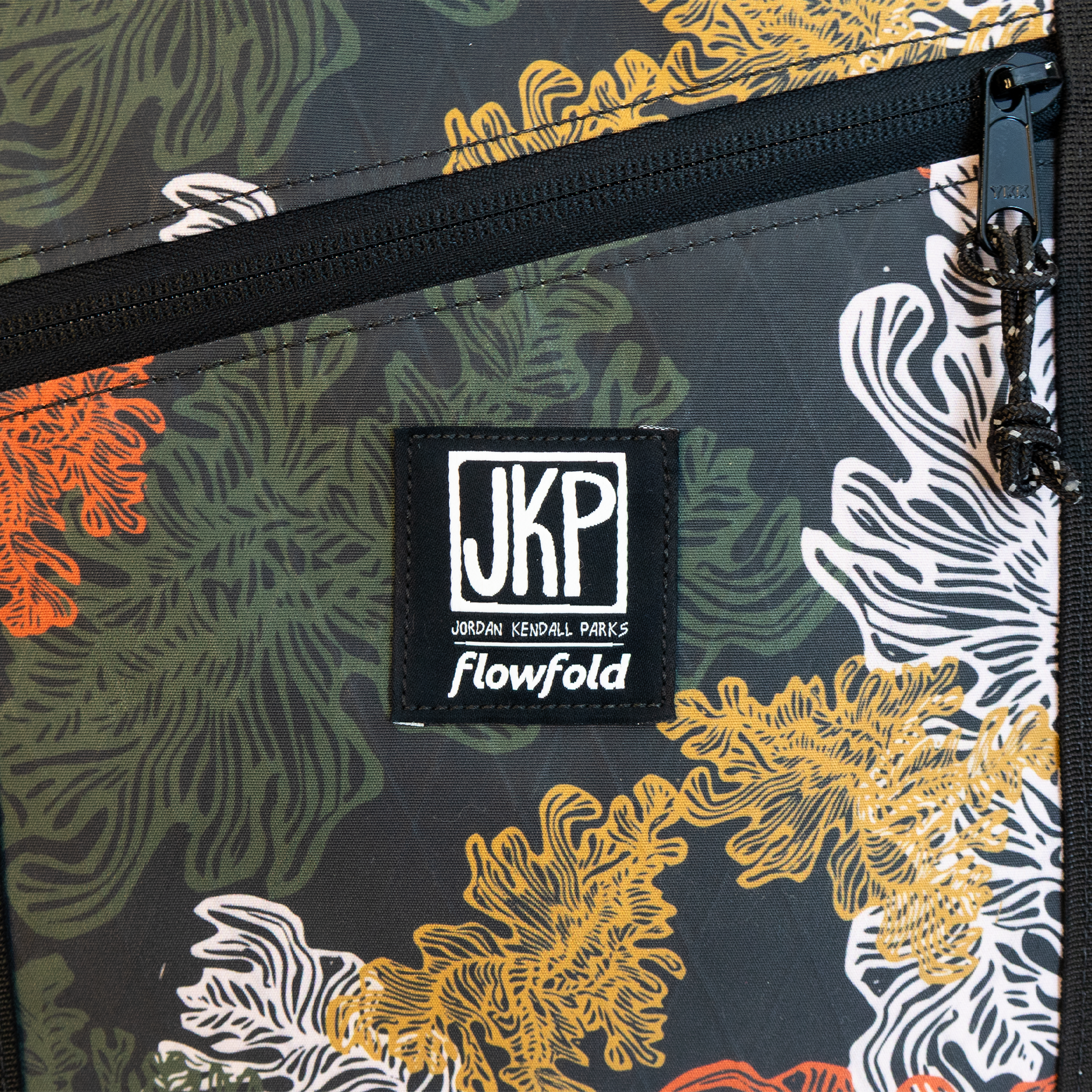 Kelp -patterned bag with JKP Flowfold logo on a dark background