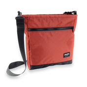 Red crossbody bag with a black strap on a white background