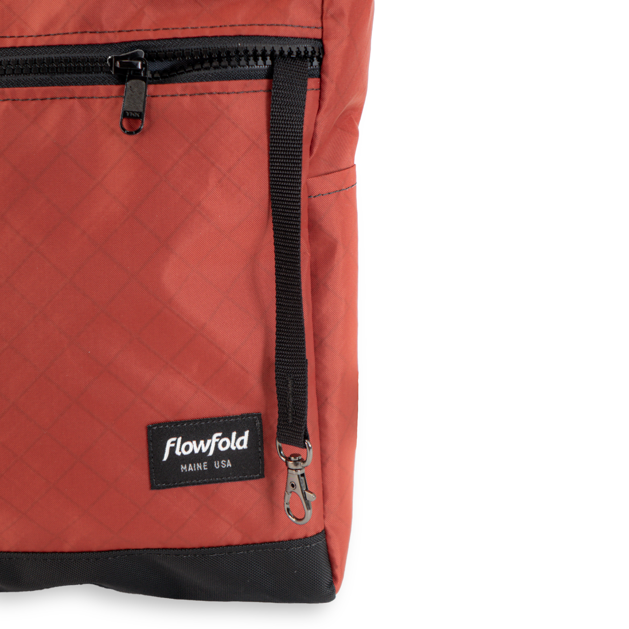 Close-up of a red bag with a black zipper and Flowfold logo on a white background, with a key leash and side pocket