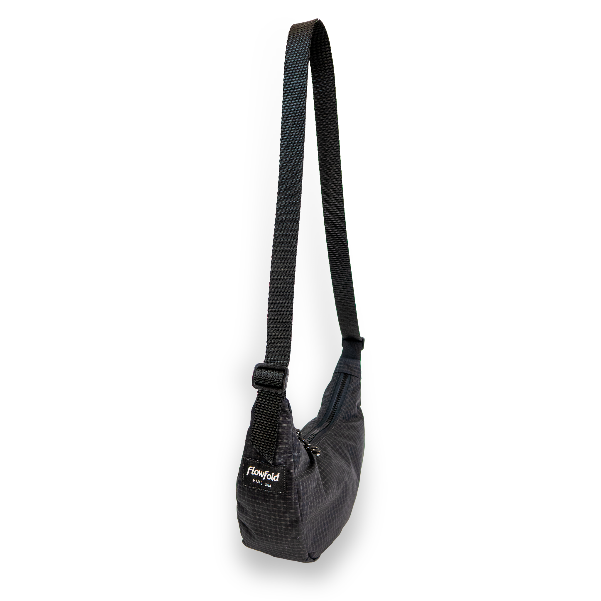 Coal crescent bag with a black strap on a white background at an angle