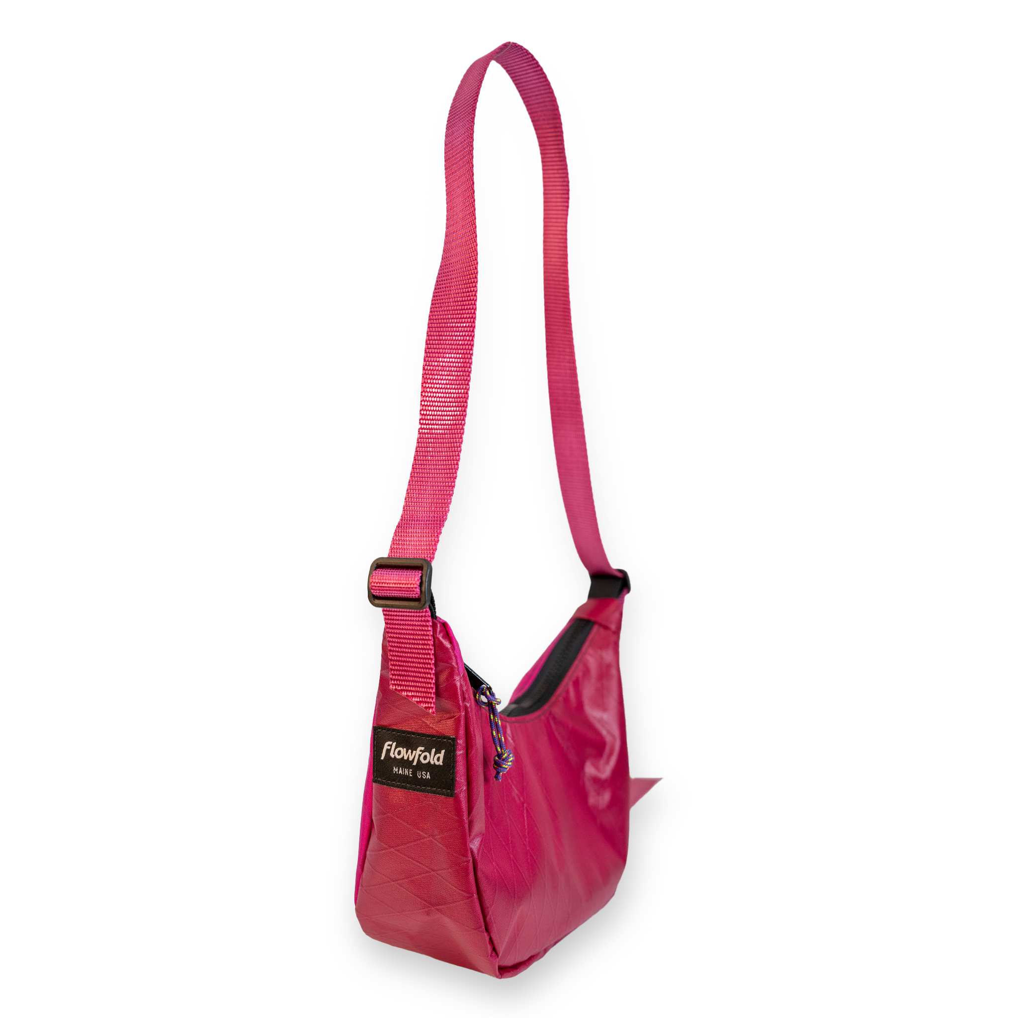 A pink shoulder bag with a matching adjustable shoulder strap, black zipper details, and a black brand label that reads 'Flowfold'.