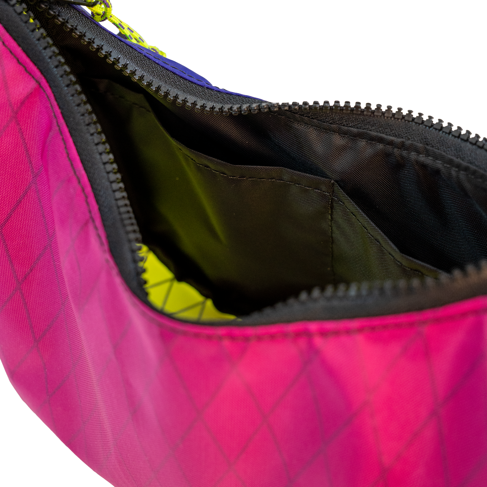 Close-up of a bright pink bag with a black zipper and black interior lining, showing a small yellow-green accent inside.
