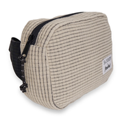 Side angle of a beige fleece grid belt bag with black strap on a white background
