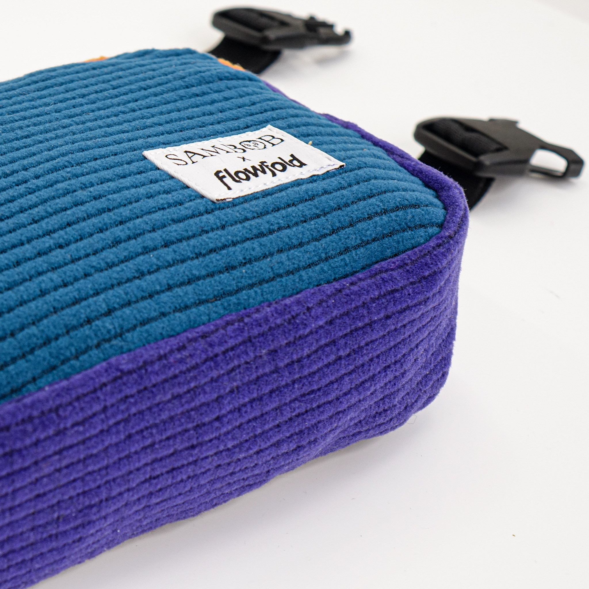 Blue and purple textured pouch with 'Sambob x Flowfold' branding on a white background