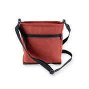 Red crossbody with black straps on a white background