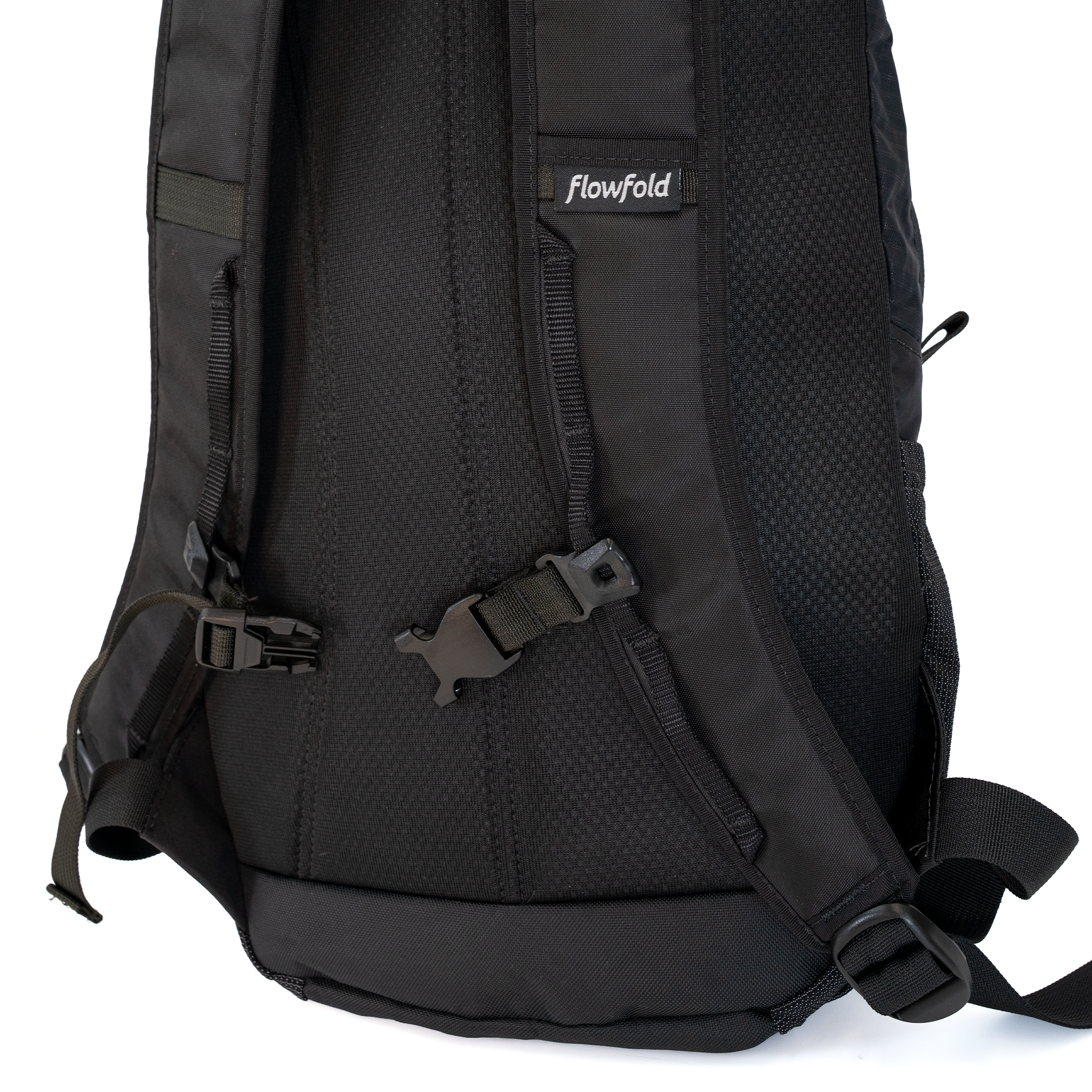 Close-up of the back of a black Flowfold backpack, showing the padded mesh back, adjustable straps, and sternum strap against a white background.