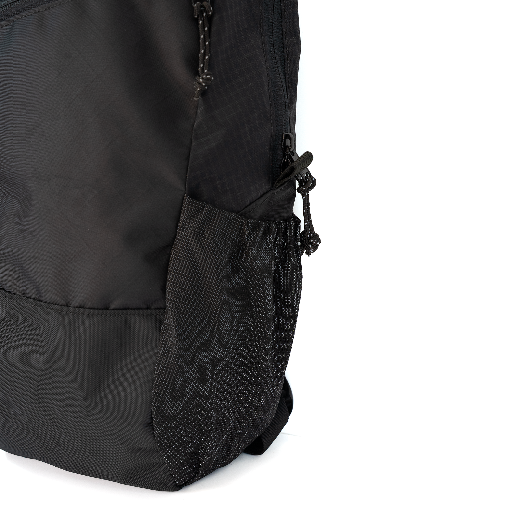 Close-up of a black backpack showing a mesh stretchy outside pocket on a white background.