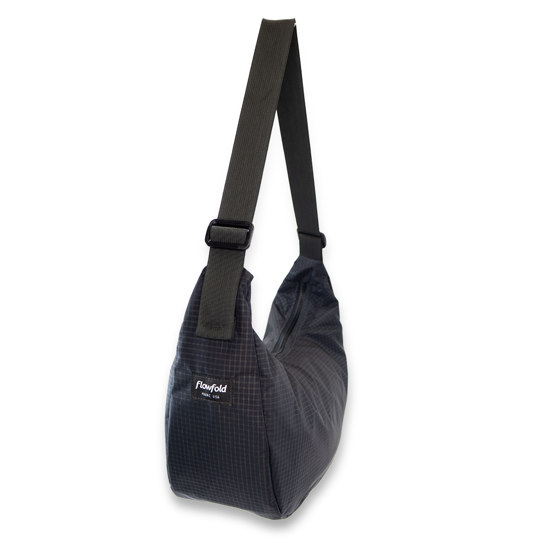 Black crescent bag with a strap on a white background