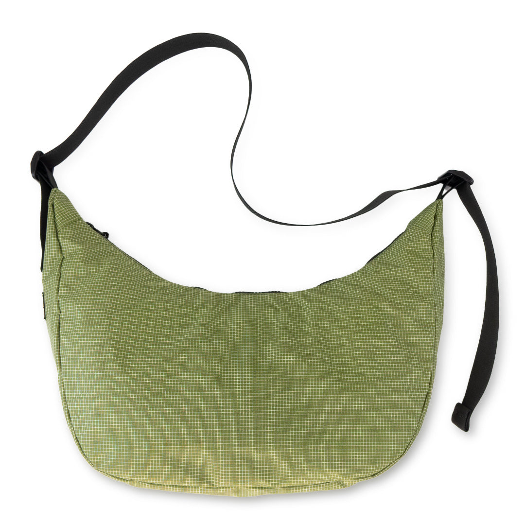 Green crescent bag with black straps on a white background
