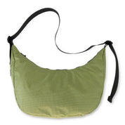 Green crescent bag with black straps on a white background