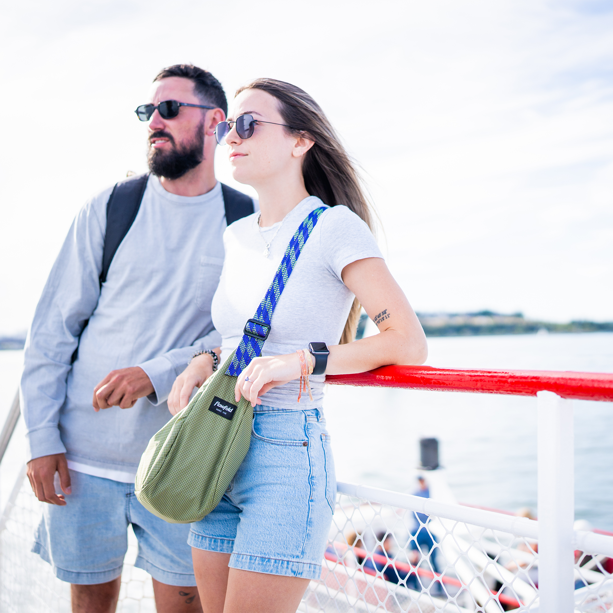 Two people standing on a boat with a scenic background