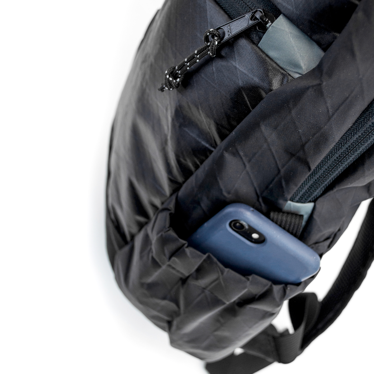 Flowfold 18L Optimist large backpack with water bottle sleeves close up with phone in pocket 